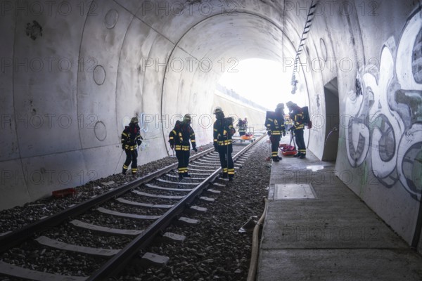 Firefighters working in a graffiti-covered tunnel, fire brigade exercise on the Hermann Hesse railway, Ostelsheim, Germany