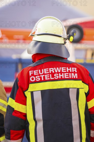 Firefighter from behind wearing colorful protective clothing and helmet, fire department exercise on the Hermann Hesse railway, Ostelsheim, Germany