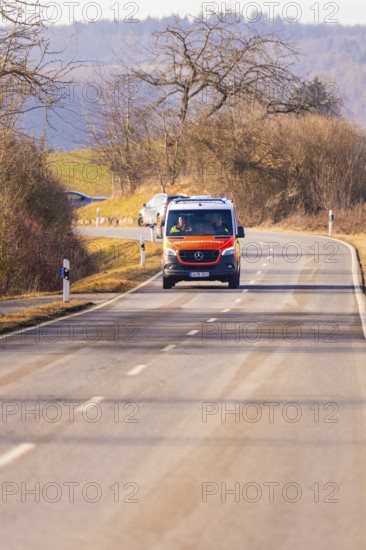 An ambulance drives along an empty country road, fire department exercise on the Hermann Hesse railway, Ostelsheim, Germany