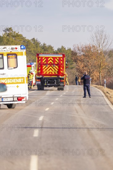 Emergency vehicles and personnel in action on a country road in winter, fire department exercise on the Hermann Hesse railway, Ostelsheim, Germany
