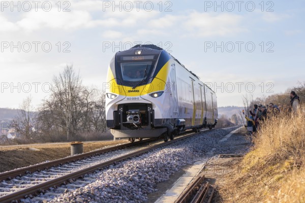 Modern train travels on tracks through rural winter landscape under clear skies, fire brigade exercise on the Hermann Hesse Railway, Ostelsheim, Germany