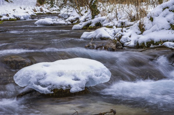 Small watercourse in winter with ice floes and mossy stones, Brühlbach below Urach Waterfall, Bad Urach, Swabian Alb, Baden-Württemberg, Germany