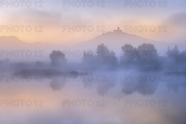 Landscape with lake at dawn at sunrise, fog rising, Wachsenburg fortress reflected in still water, castle of the castle ensemble Drei Gleichen, Thuringian Burgenland, Mühlberg, Thuringia, Germany