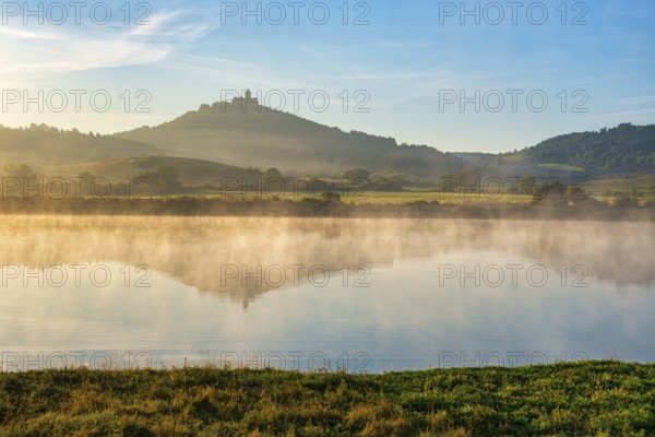 Wachsenburg Castle is reflected in the still water of a lake in the morning light, fog rises, castle of the castle ensemble Drei Gleichen, Thuringian Burgenland, Mühlberg, Thuringia, Germany