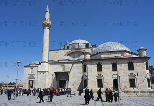 Visitors enter a historic mosque with several domes and minarets, prayer in front of the mosque, Konya Sultan Selim Camii, Konya, Central Anatolia, Turkey