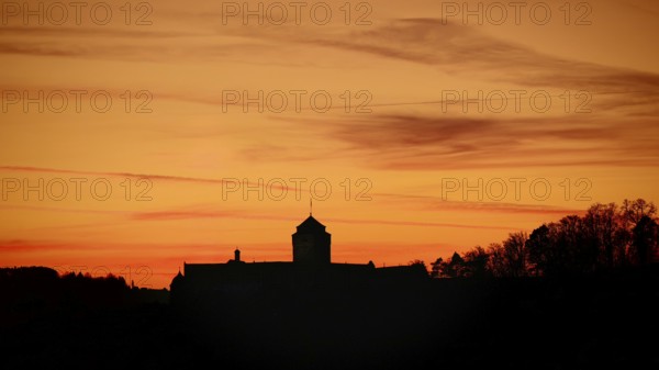 Silhouette of a castle at sunset, warm tones above the horizon, view of Rosenberg Fortress, Kronach, Frankenwald nature park Park