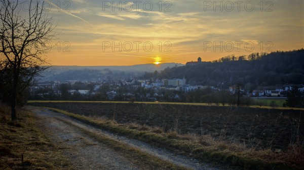 Sunset behind a small town, warm light over hills and a country road, view of Rosenberg Fortress, Kronach, Frankenwald nature park Park