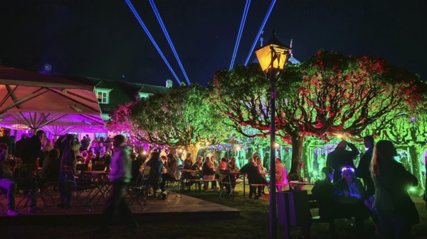Colourfully lit garden at night, full of people, with atmospheric lighting, Kronach glows, Frankenwald nature park Park
