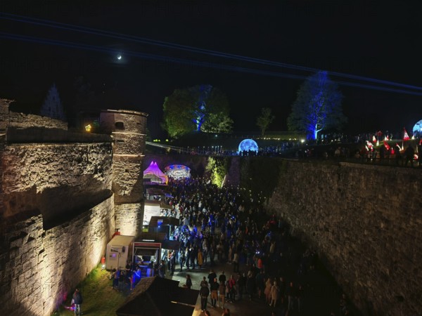 Night shot of a festival near a castle with lights and laser beams, Kronach glows, Frankenwald nature park Park