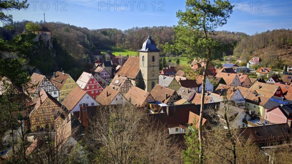 Picturesque village with colorful half-timbered houses and church tower, surrounded by hills, view of Betzenstein, Franconian Switzerland