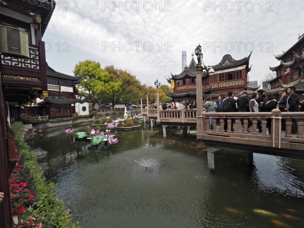 Bridge over a pond with historical background and buildings, Yuyuan Garden, Shanghai, China