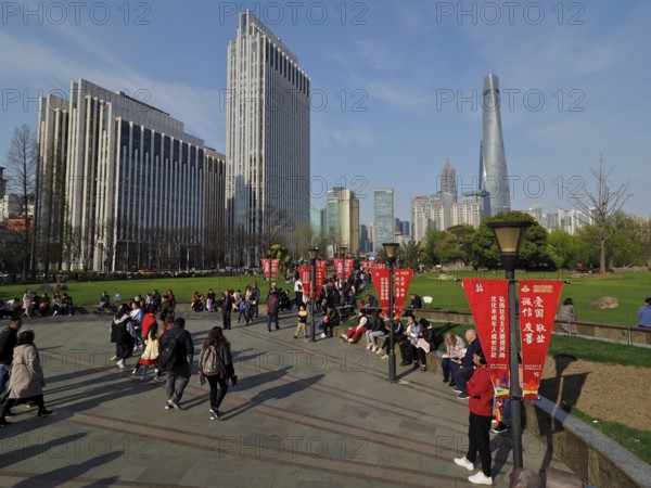 A busy municipal park with people and skyscrapers, Shanghai Tower, in the background, Shanghai, China