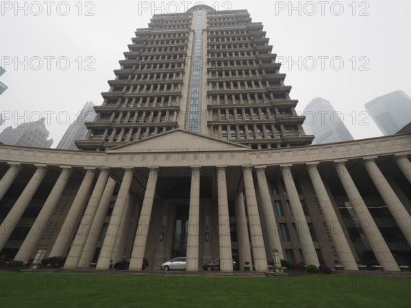 Large symmetrical building with pillars and lawn in an urban environment, Pudong, Shanghai, China