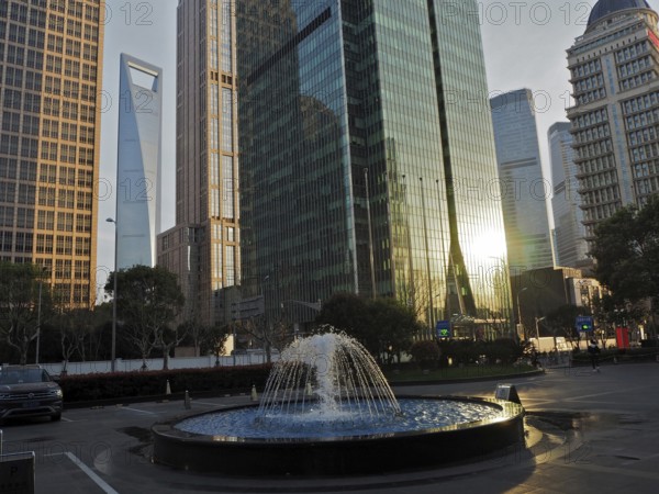 Skyscrapers with reflective glass facades and a fountain in the city center, Pudong, Shanghai, China