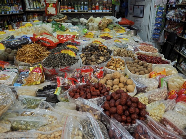 Various dried foods and spices in packaging and trays at a busy market, Wet Market, French Concession, Shanghai, China