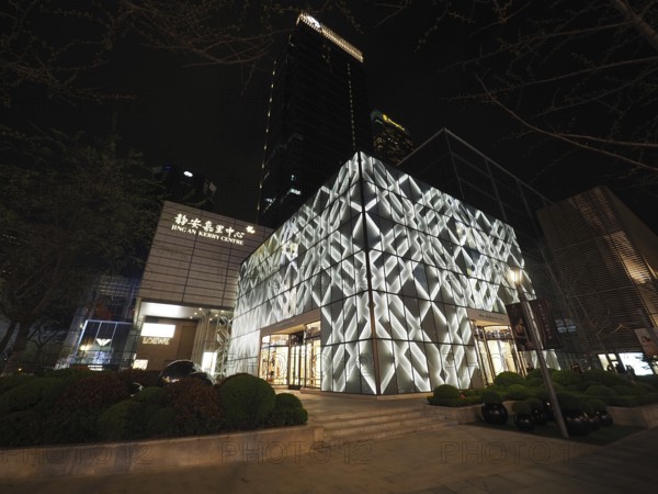 Modern building, Jing An Kerry Centre, at night with illuminated façade in an urban setting, Shanghai, China