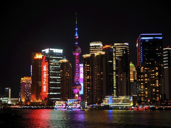 Illuminated skyline with the iconic Oriental Pearl Tower shining in the light at night, Shanghai, China