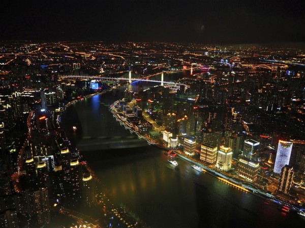 Night view of illuminated city with river and bridges forming a glowing skyline, Shanghai, China