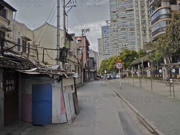 Urban street with old and modern buildings along a sidewalk, Shanghai, China