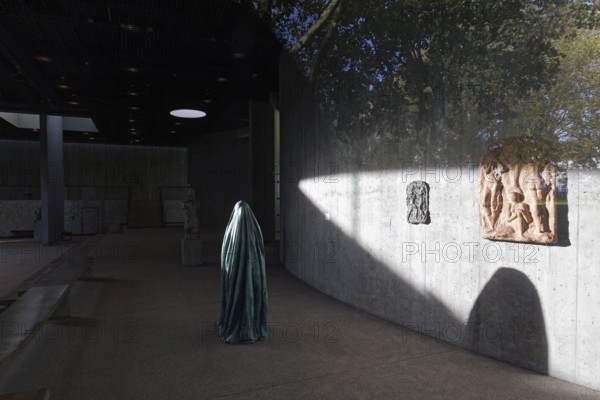 Statue of a veiled figure in the Lehmbruck Museum, looking through window, self-portrait as a ghost by sculptor Alicja Kwade, Duisburg, North Rhine-Westphalia, Germany
