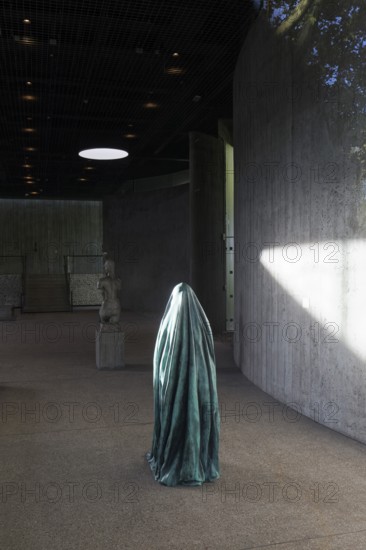 Statue of a veiled figure in the Lehmbruck Museum, looking through window, self-portrait as a ghost by sculptor Alicja Kwade, Duisburg, North Rhine-Westphalia, Germany