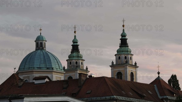 Three church towers and a dome rise against a cloudy evening sky, Piran, Slovenia