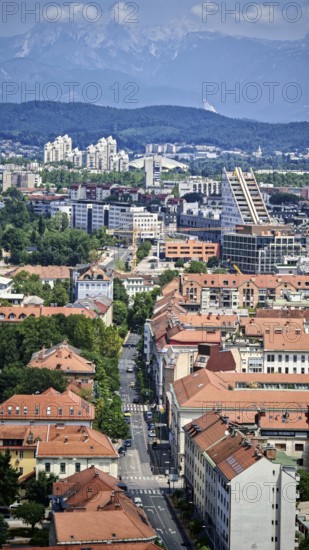 View of urban architecture with distinctive red roofs and mountain landscape, Ljubljana, Slovenia