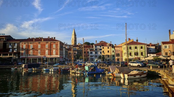 A picturesque harbor with boats and historic buildings at sunset, Izola, Slovenia