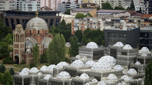 Church next to modern building with distinctive domes, National Library, Pristina, Kosovo