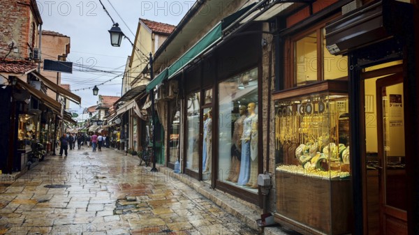 An old town alley with shops and wet pavement, Ohrid, North Macedonia