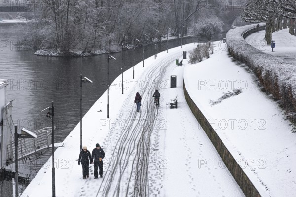 Only a few passers-by and cyclists move along the banks of the Main due to weather conditions. Heavy snowfalls have caused another onset of winter in the Main metropolis, Osthafen, Frankfurt am Main, Hesse, Germany