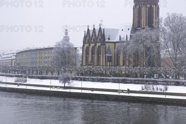 A passerby walks along the banks of the Main with an umbrella. Heavy snowfalls have caused another onset of winter in the Main metropolis, Osthafen, Frankfurt am Main, Hesse, Germany