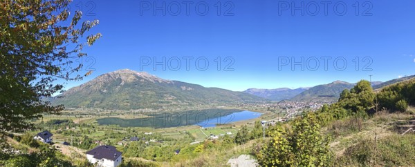 Wide view over a lake and mountains under a clear blue sky, view from above over Lake Plav, Montenegro