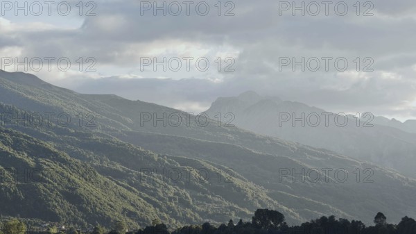 Hilly landscape with clouds, light fog in a quiet valley, Plav Lake, Montenegro