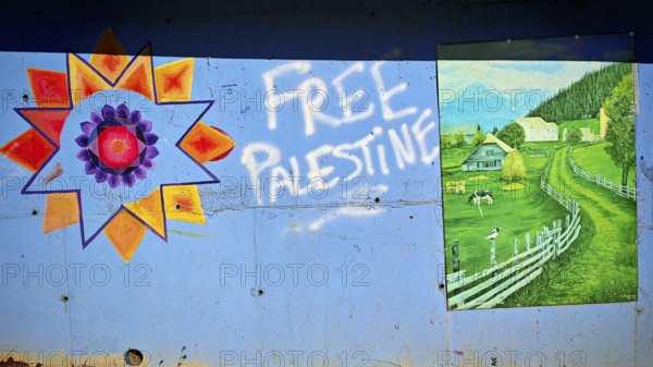 Wall art with graffiti free Palestine and a picture of a green landscape with houses and mountains, Montenegro