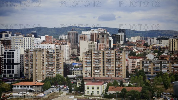 Dense urban landscape with skyscrapers and mountains in the background, Pristina, Kosovo