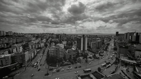An urban street scene in black and white, with cloudy sky, Pristina, Kosovo