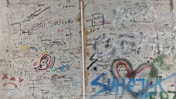 Wall full of colorful graffiti and doodles separating two different sections, Pristina, Kosovo