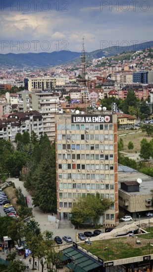 Skyscraper with signs in the city center under a cloudy sky, Pristina, Kosovo