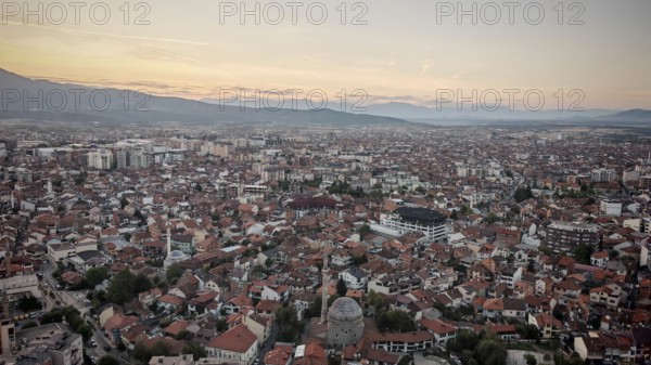 Extensive view of the city in evening light with mosque and mountains on the horizon, Prizren, Kosovo