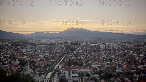View of a city at sunset with river surrounded by mountains in the distance, Prizren, Kosovo