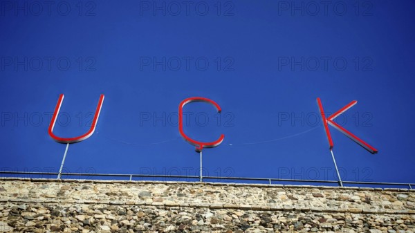 Large KLA lettering on a stone wall under a blue sky, Prizren, Kosovo
