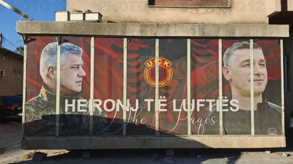 Portrait mural with KLA symbols war heroes on a building, Kosovo