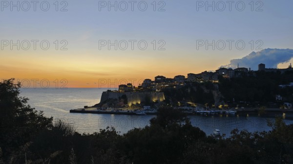 Coastal town at sunset, illuminated silhouette and calm sea, Ulcinj, Montenegro