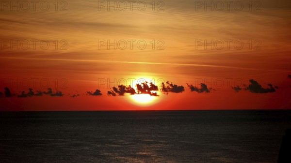Dramatic sunset with orange sky and calm lake, Montenegro