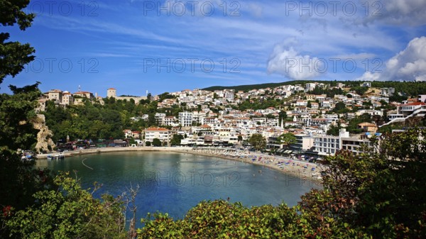 Picturesque coastal town on a bay under blue sky, surrounded by greenery, view of Ulcinj, Montenegro