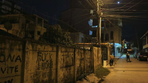 Dark street scene with graffiti and illuminated street lamps creates a tense atmosphere, Tirana, Albania