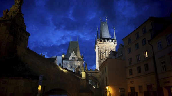 Night view of impressively illuminated historic towers and buildings, Prague