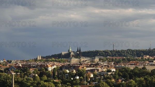 Panoramic view of a city with historic buildings under a cloudy sky, Prague