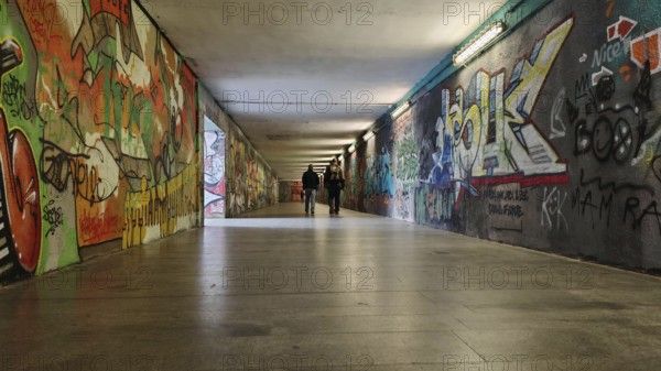 Long tunnel with colorful graffiti on the walls, some people can be seen in the background, Prague, Czech Republic